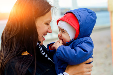 mother holding baby outdoors in autumn