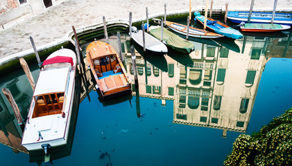 Fototapeta na wymiar Boats and building reflection in Venetian Canal
