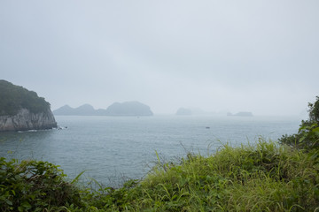 Vietnam, halong, catba. Rocky island in azure sea. Blue cloudless sky. Smaller islands in background