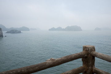 Vietnam, halong, catba. Rocky island in azure sea. Blue cloudless sky. Smaller islands in background
