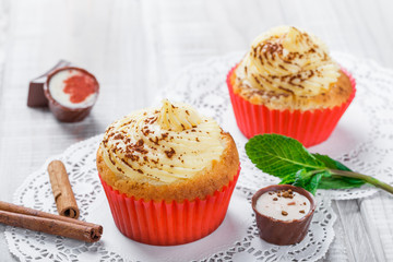 Tasty cupcakes with candies and chocolate on light background close up