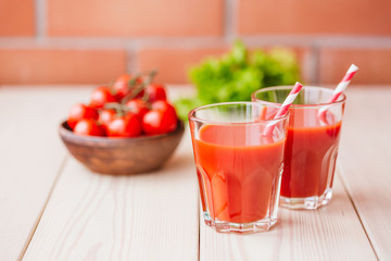 Tomato juice in a glass on wooden table. Love for a healthy raw food concept.