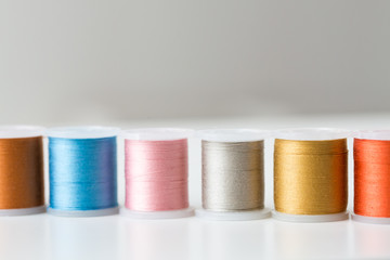 row of colorful thread spools on table