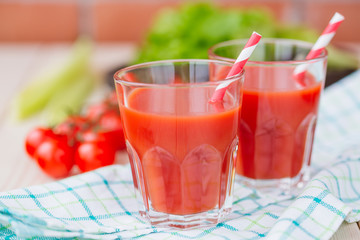Tomato juice in a glass on wooden table. Love for a healthy raw food concept.