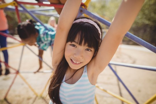Portrait of happy girl playing on dome climber