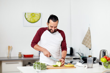 man with blender and fruit cooking at home kitchen