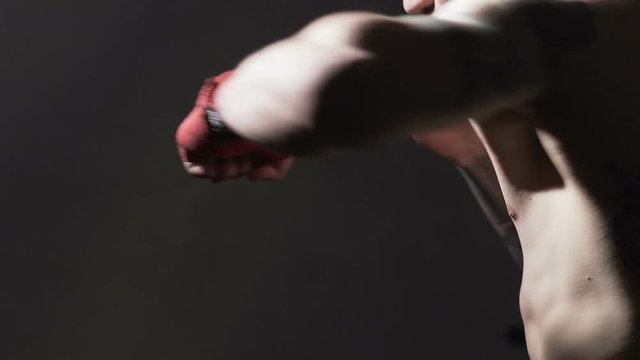 Muay Thai boxing, strong tattooed male training before fight in gym, slow-motion