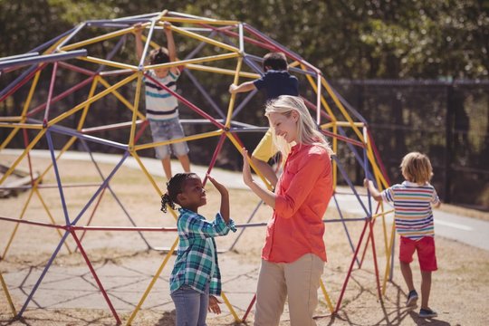 Happy trainer and girl giving high five to each other