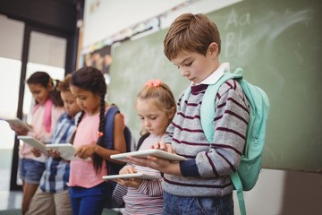 Attentive schoolkids using digital tablet in classroom