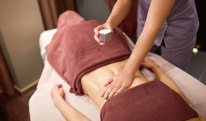 woman lying and having massage with hot oil at spa