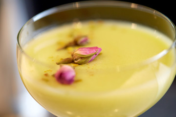 close up of glass with creamy cocktail at bar