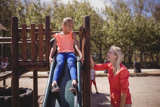 Trainer interacting with girl while playing on slide