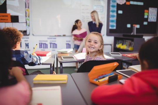 Portrait of smiling schoolgirl sitting in classroom