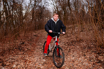 Obraz premium Cyclist Riding the Bike on a Trail in Summer Forest