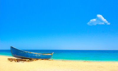 Fishing boat on tropical sand beach with single cloud