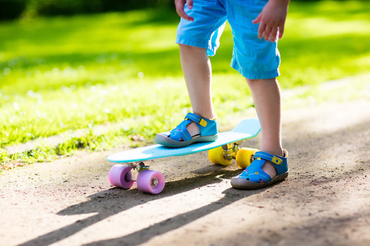 Child riding skateboard in summer park
