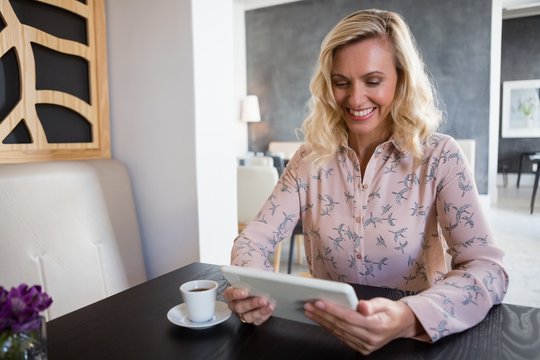 Businesswoman using digital tablet while sitting in cafe
