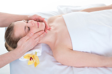 Obraz na płótnie Canvas Young woman receiving head massage by masseur at health spa