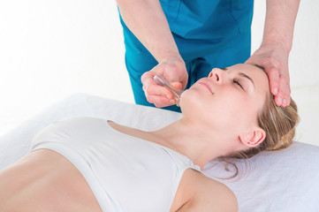 Fototapeta na wymiar spa beauty treatment and skincare. Woman getting facial massage by beautician at spa salon, close-up