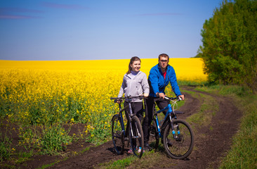 Young couple rides in rapeseed field