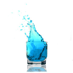 light-blue cocktail splashing on a glass on white background