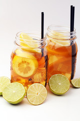 Iced tea with lemon slices and mint on white background
