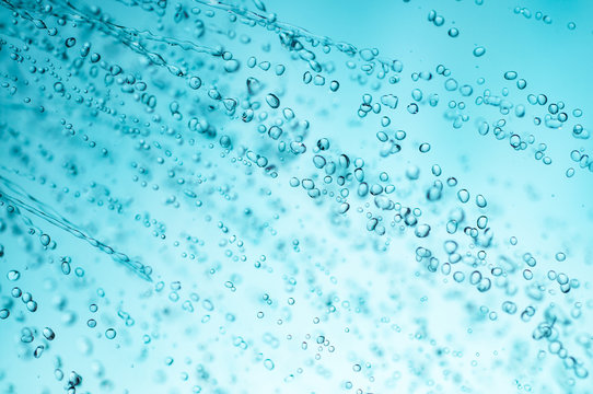 sprinkling water from shower head, closeup, blue toned photo.