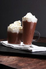Hot chocolate cocoa with whipped cream on vintage wooden backgro