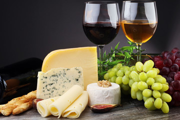 Cheese platter with different cheese and grapes and red wine