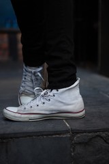 Low section of man wearing white canvas shoes