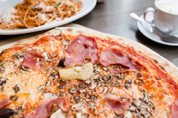 Pizza with artichoke, ham and mushrooms. the process of eating, cooking appliances