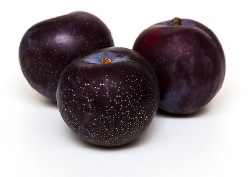 three black plums isolated