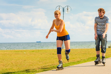 Young couple on roller skates riding outdoors