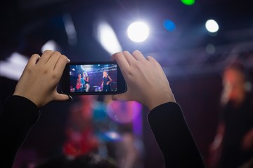 Audience recording video of band on mobile phone