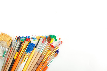 Row of artist paintbrushes closeup on artistic canvas.