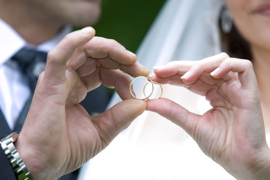 pareja de novios reci&eacute;n casados con los anillos