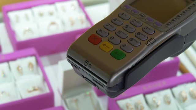 A Golden Credit Card And Credit Card Terminal POS In A Jewelry Store