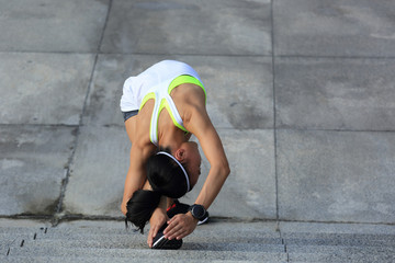 Fototapeta na wymiar young fitness sports woman warming up on stone stairs before run