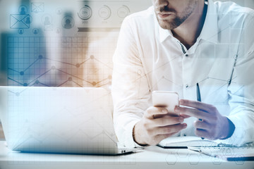 Young accountant using smartphone and laptop