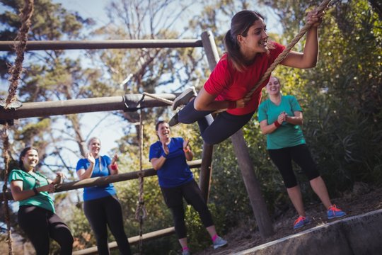 Fit Woman Climbing A Rope During Obstacle Course Training