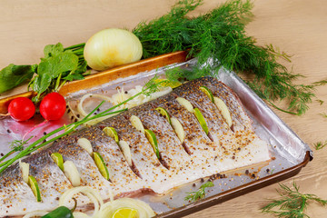 Delicious marinated fish with lemon and onion dish in the oven