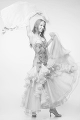 monochrome studio photo of young beautiful dancing woman in long dress with motion blur effect. low contrast images