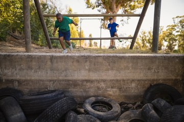 Boys exercising on outdoor equipment during obstacle course