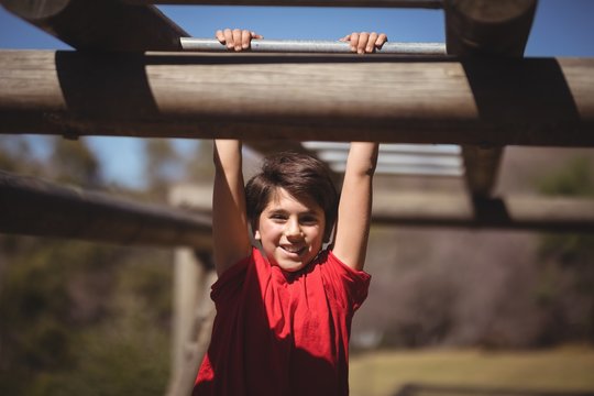 Portrait of happy boy exercising on monkey bar 