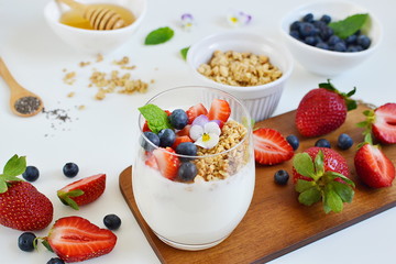 Yogurt with granola, honey, blueberries and strawberries, healthy breakfast