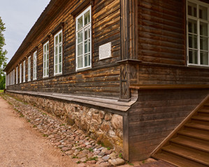 The merchant's house/Wooden merchant's house. One floor. Steps, a porch. Many windows. The basement is made of stone. Russia, Pskov region, summer.