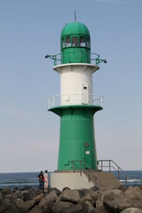 Fototapeta na wymiar Grün weißer Leuchtturm an der Hafeneinfahrt in Warnemünde