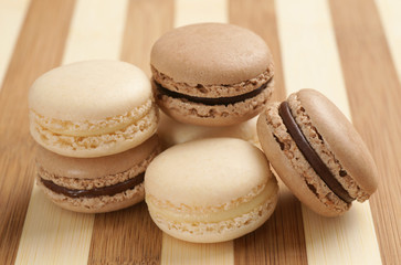 Chocolate and Vanilla Macarons on Striped Wooden Board