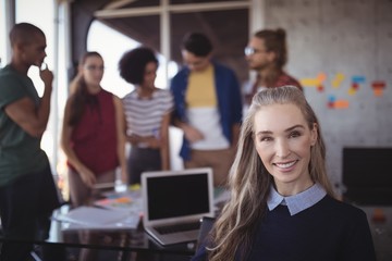 Smiling female manager with creative team in office