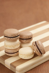 Chocolate and Vanilla Macarons on Striped Cutting Board